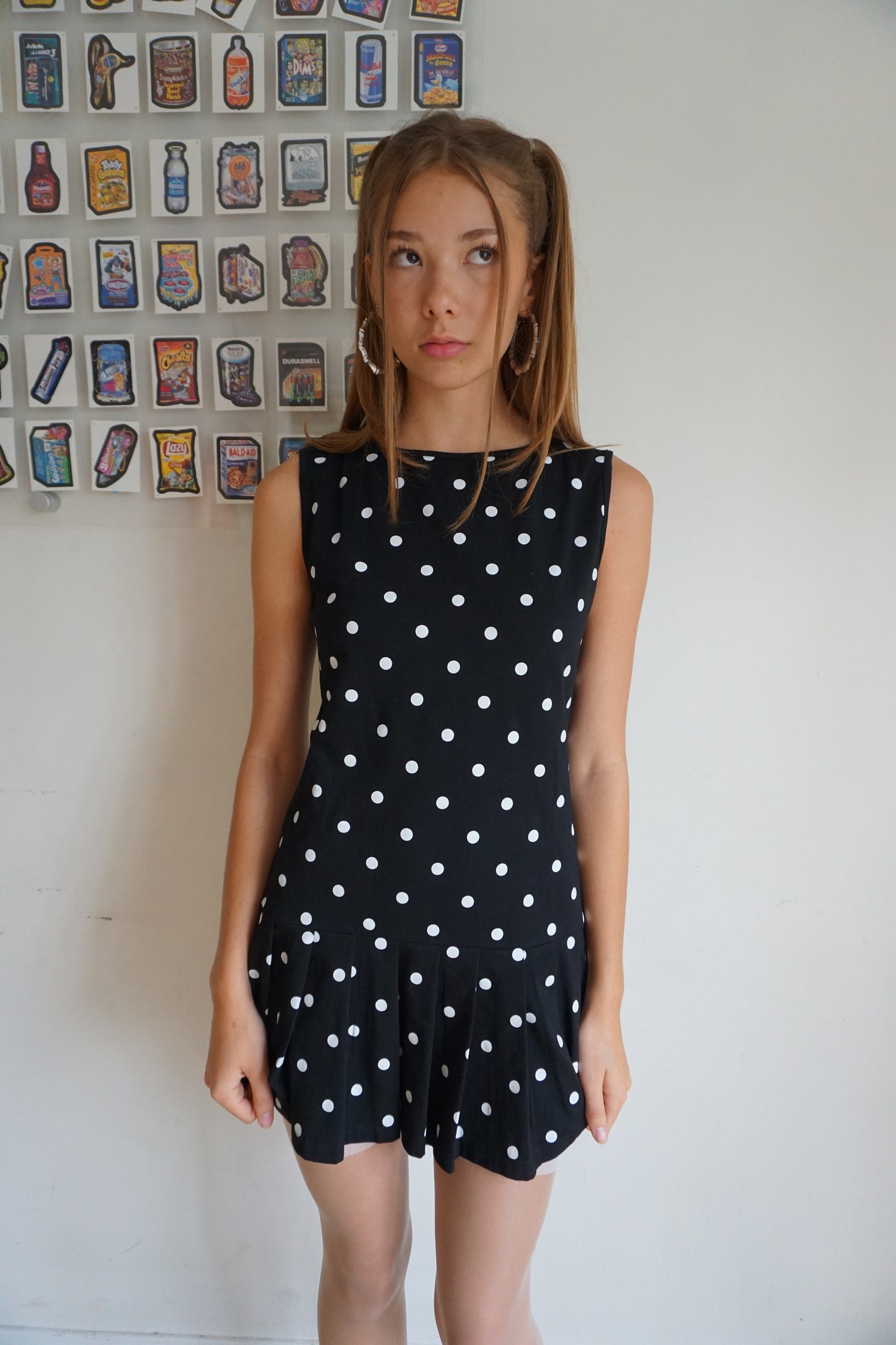 Girl wearing a pleated drop waist black and white polka dot dress