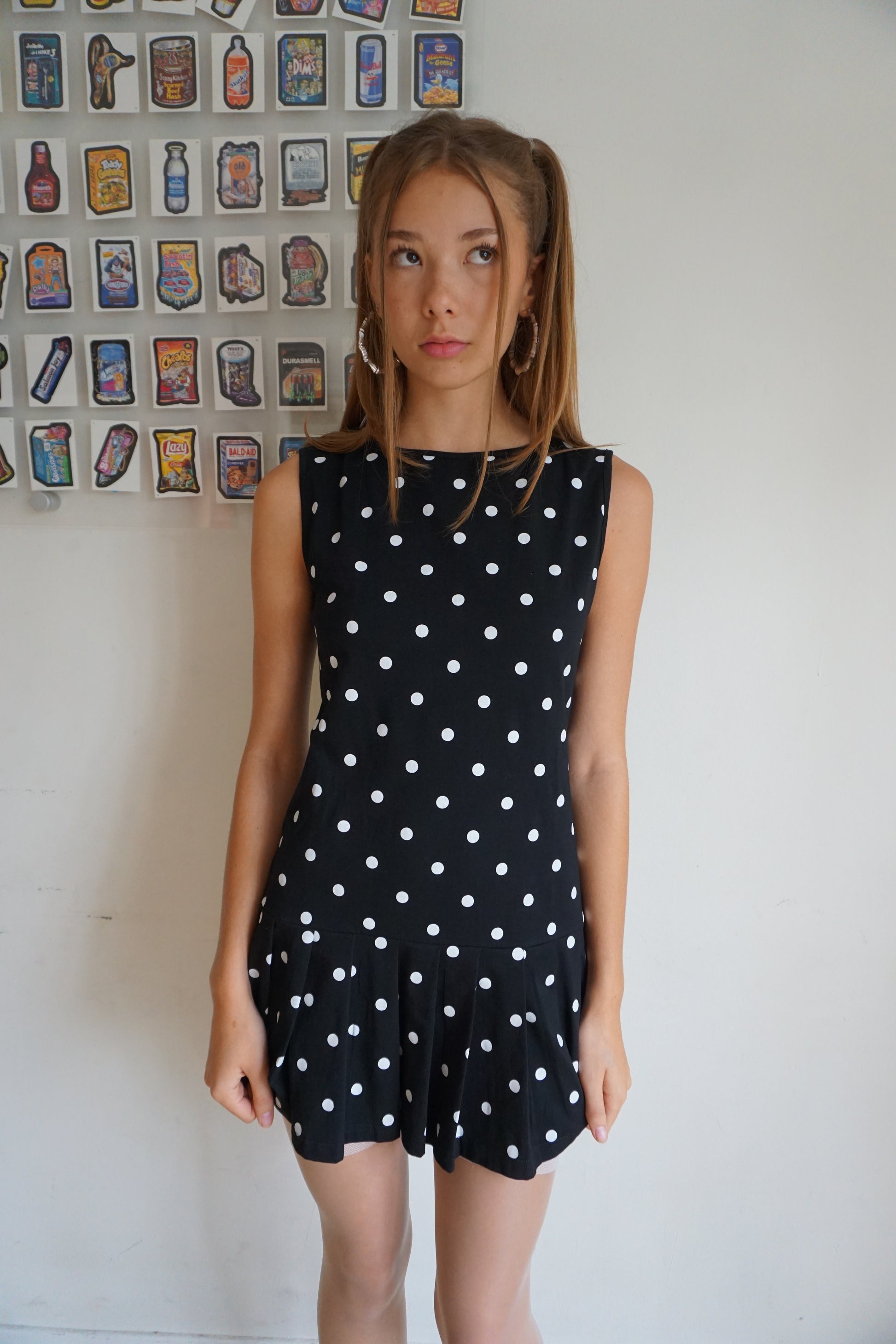 Girl wearing a pleated drop waist black and white polka dot dress