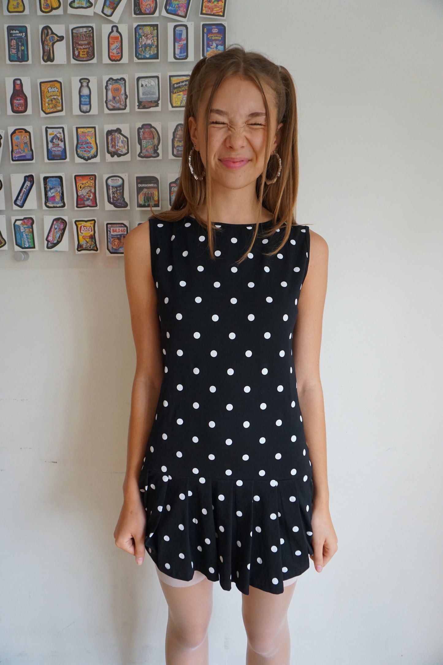 Girl wearing a pleated drop waist black and white polka dot dress