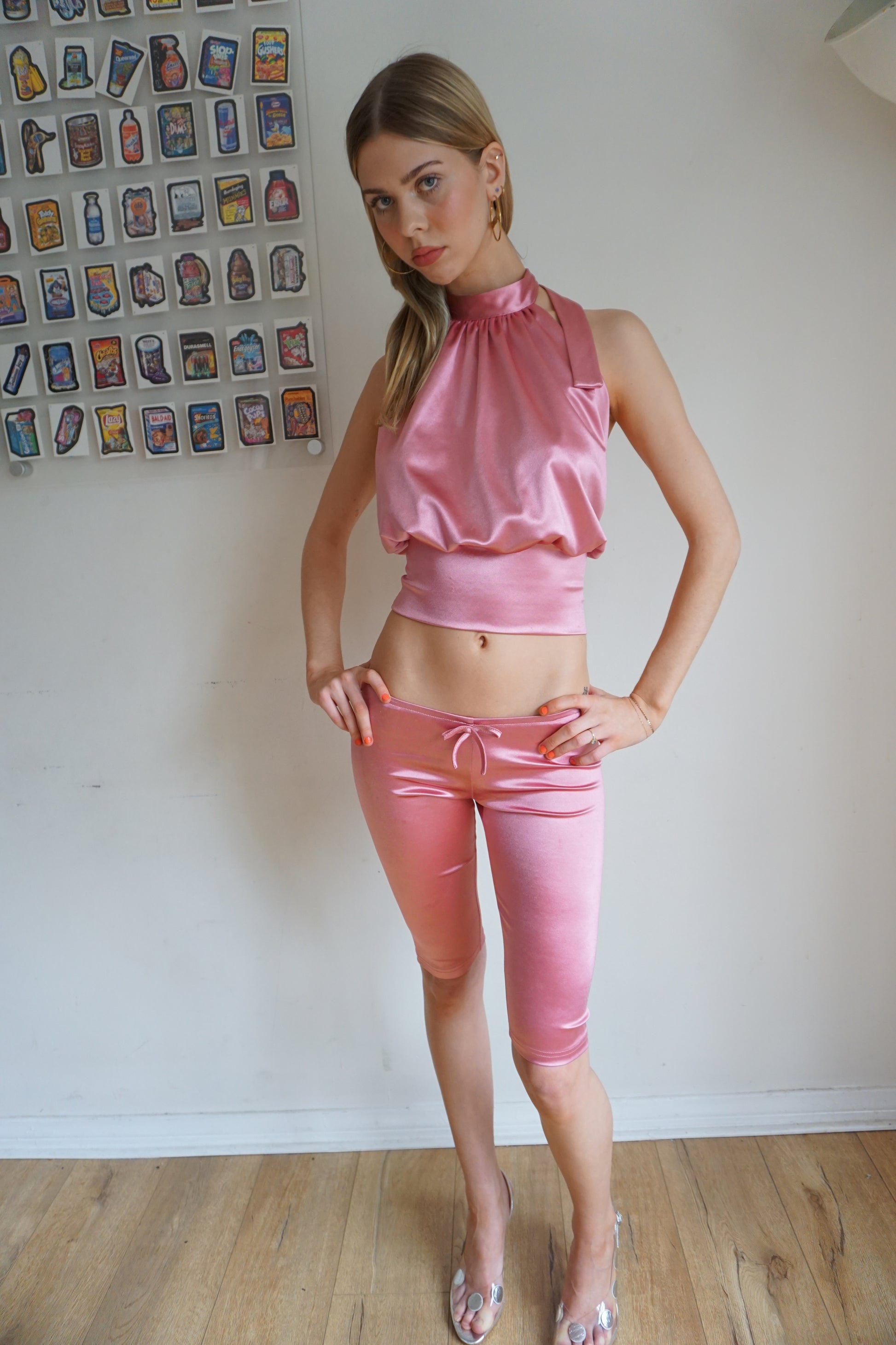 Girl wearing blush pink satin halter top with open back and matching capris