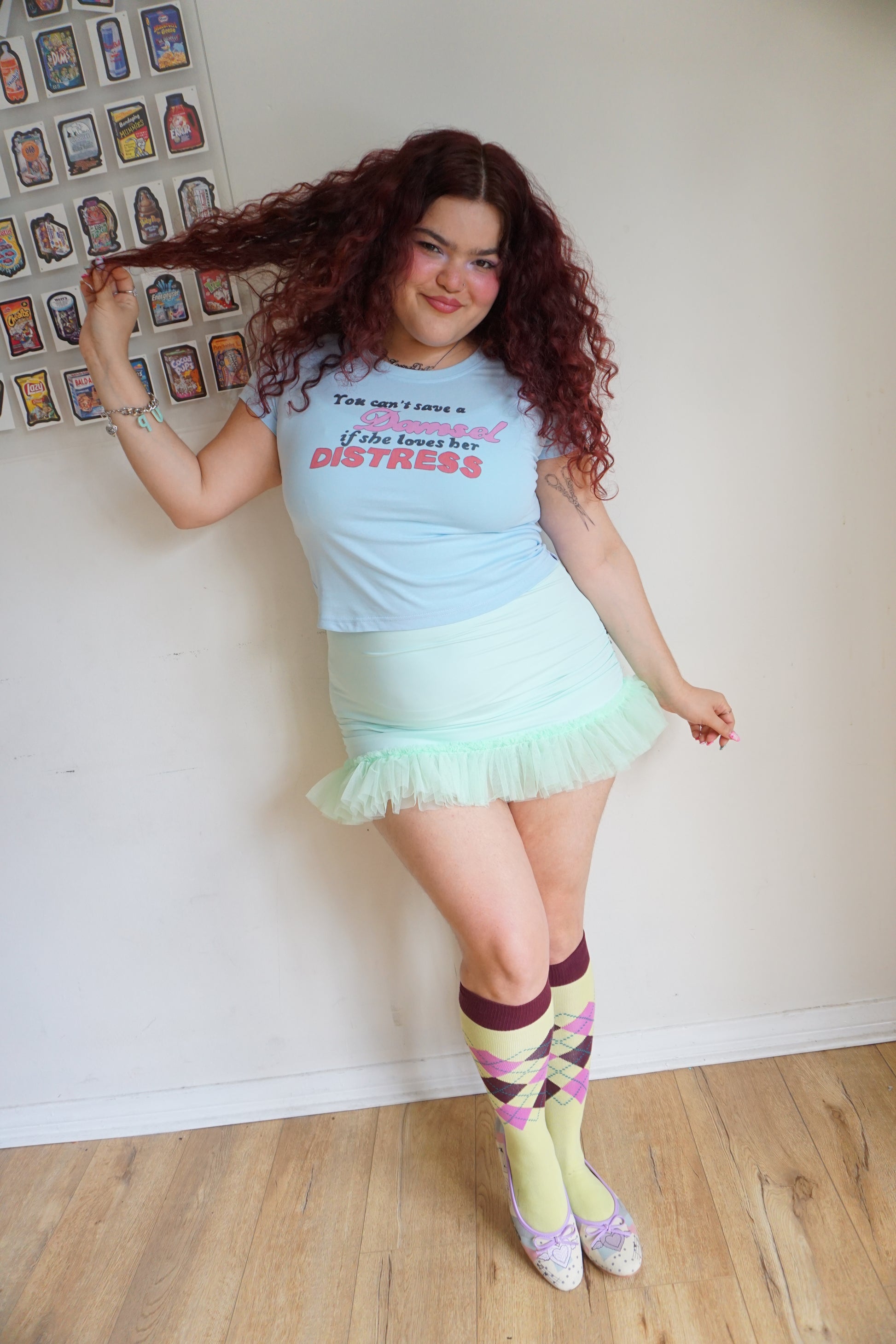 woman wearing blue baby t shirt that says you can’t save a damsel if she loves her distress