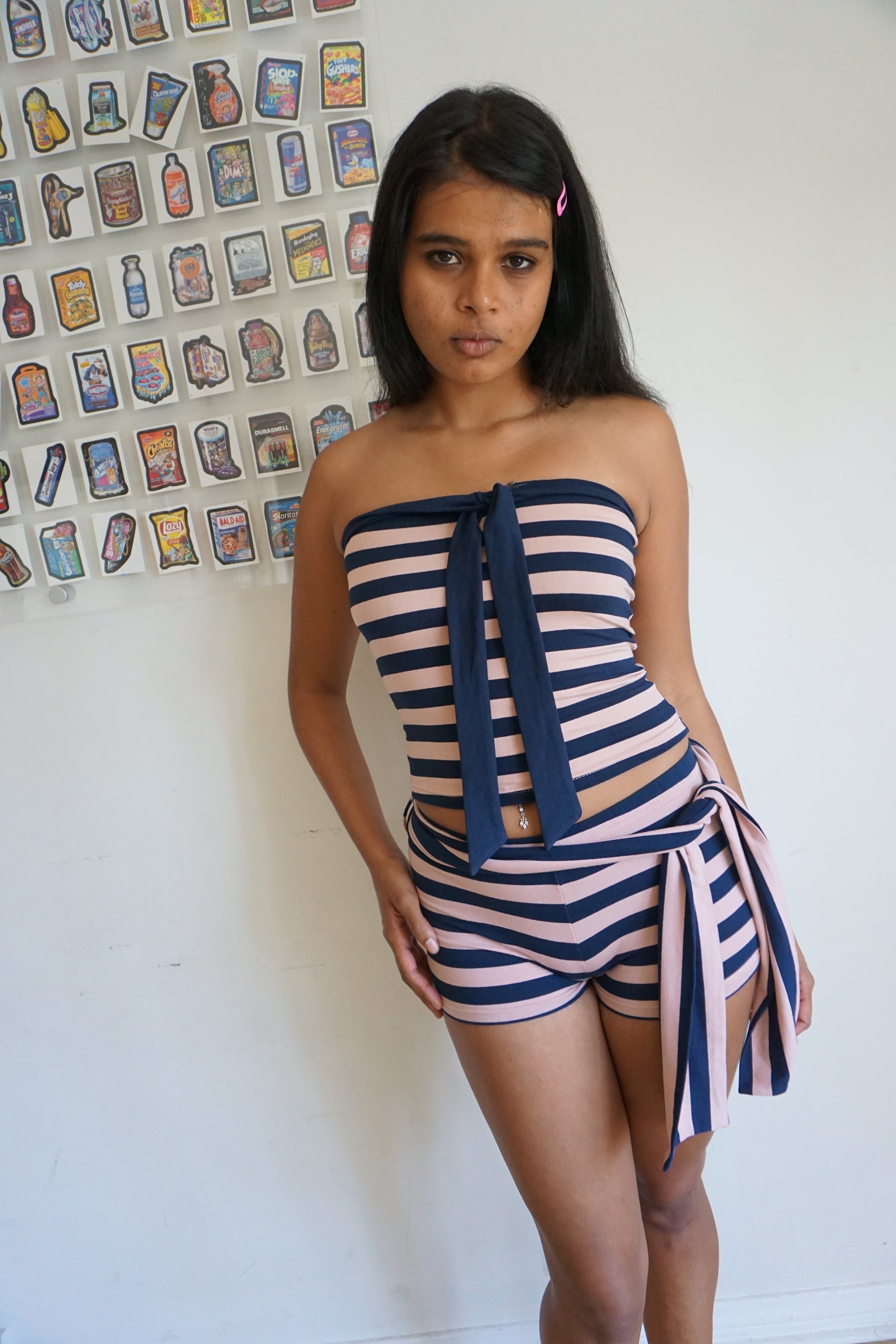 Woman wearing a pink and navy blue tube top and shorts set