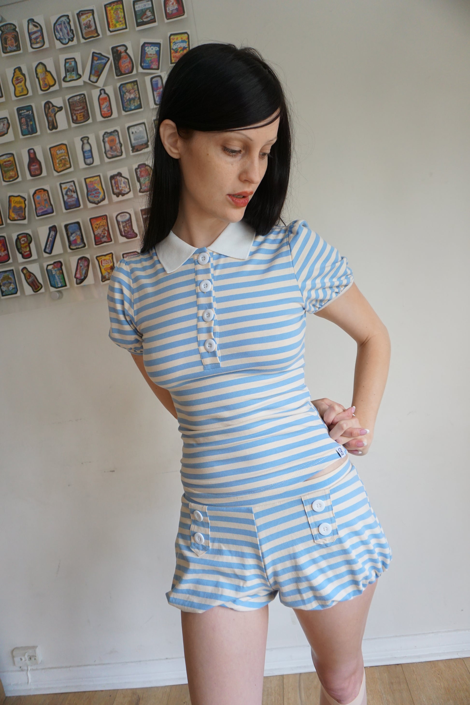 Girl with brown hair wearing a light blue/white polo and shorts set
