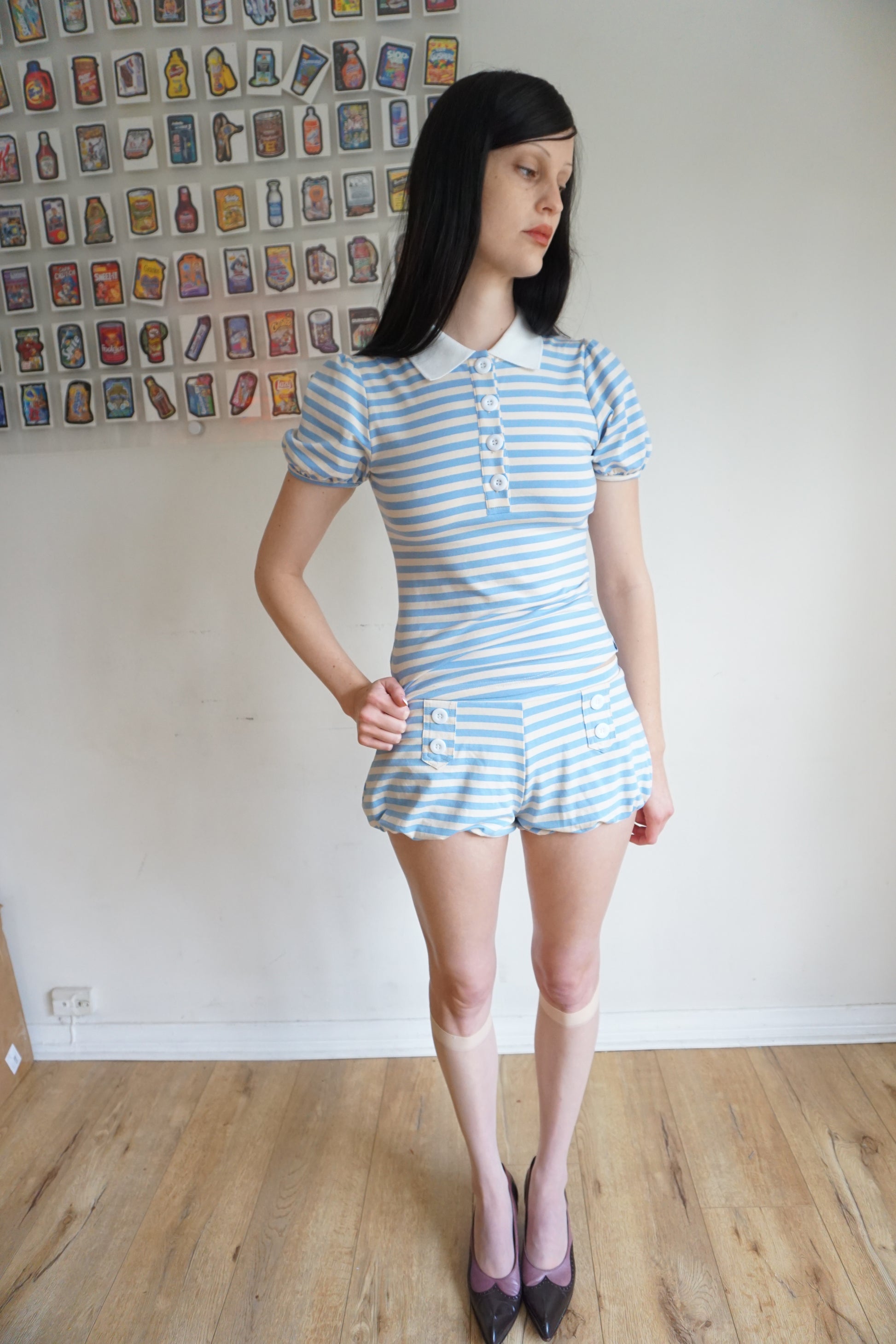 Girl with brown hair wearing a light blue/white polo and shorts set