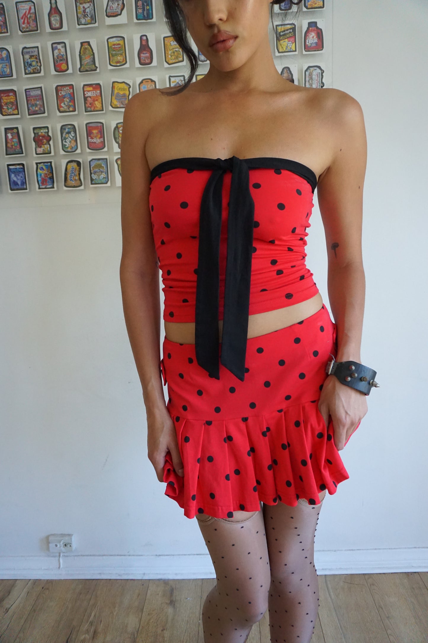 Girl wearing red tube top with black polka dots and black tie