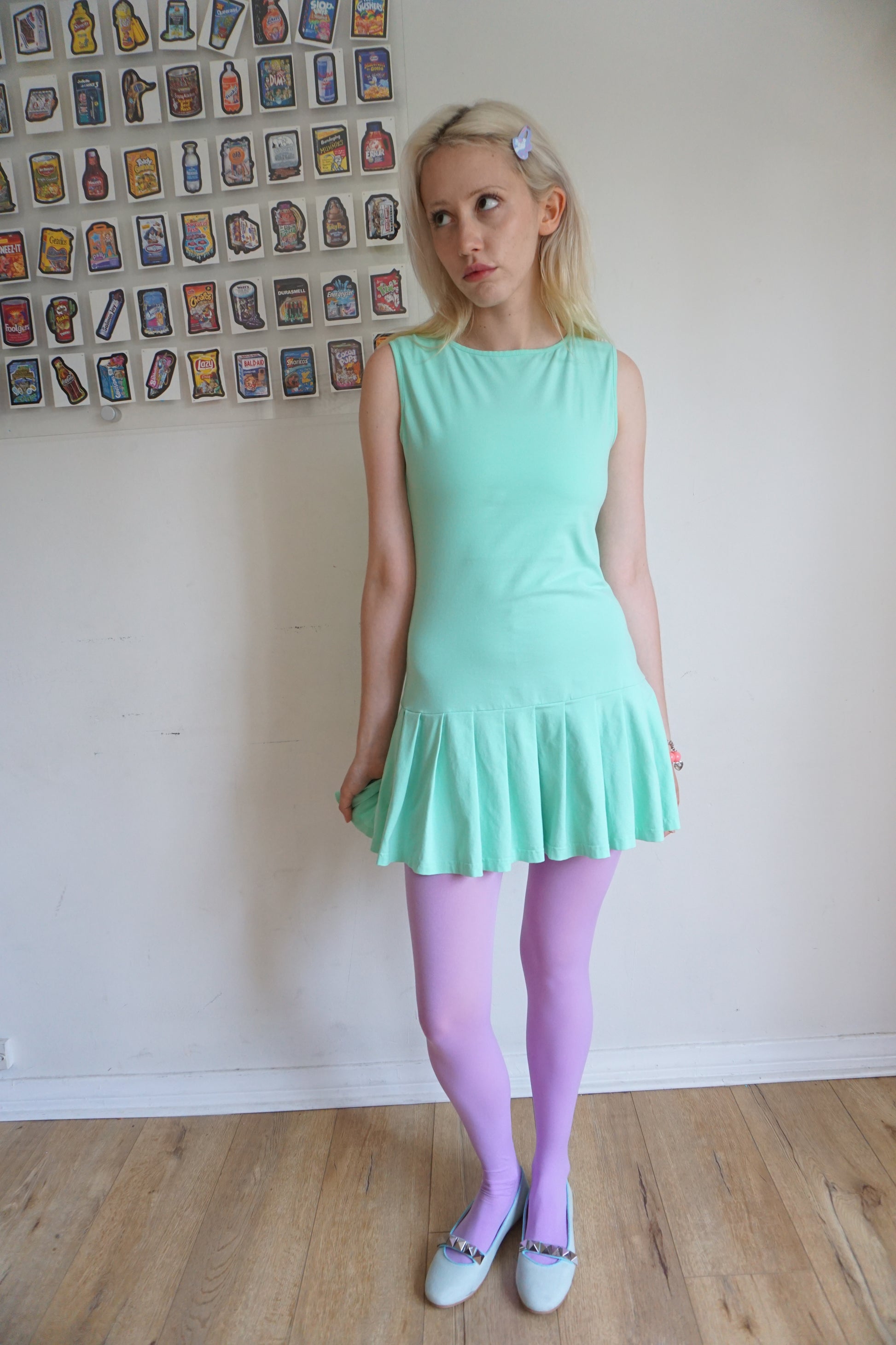 blonde girl wearing a mint green drop waist pleated dress