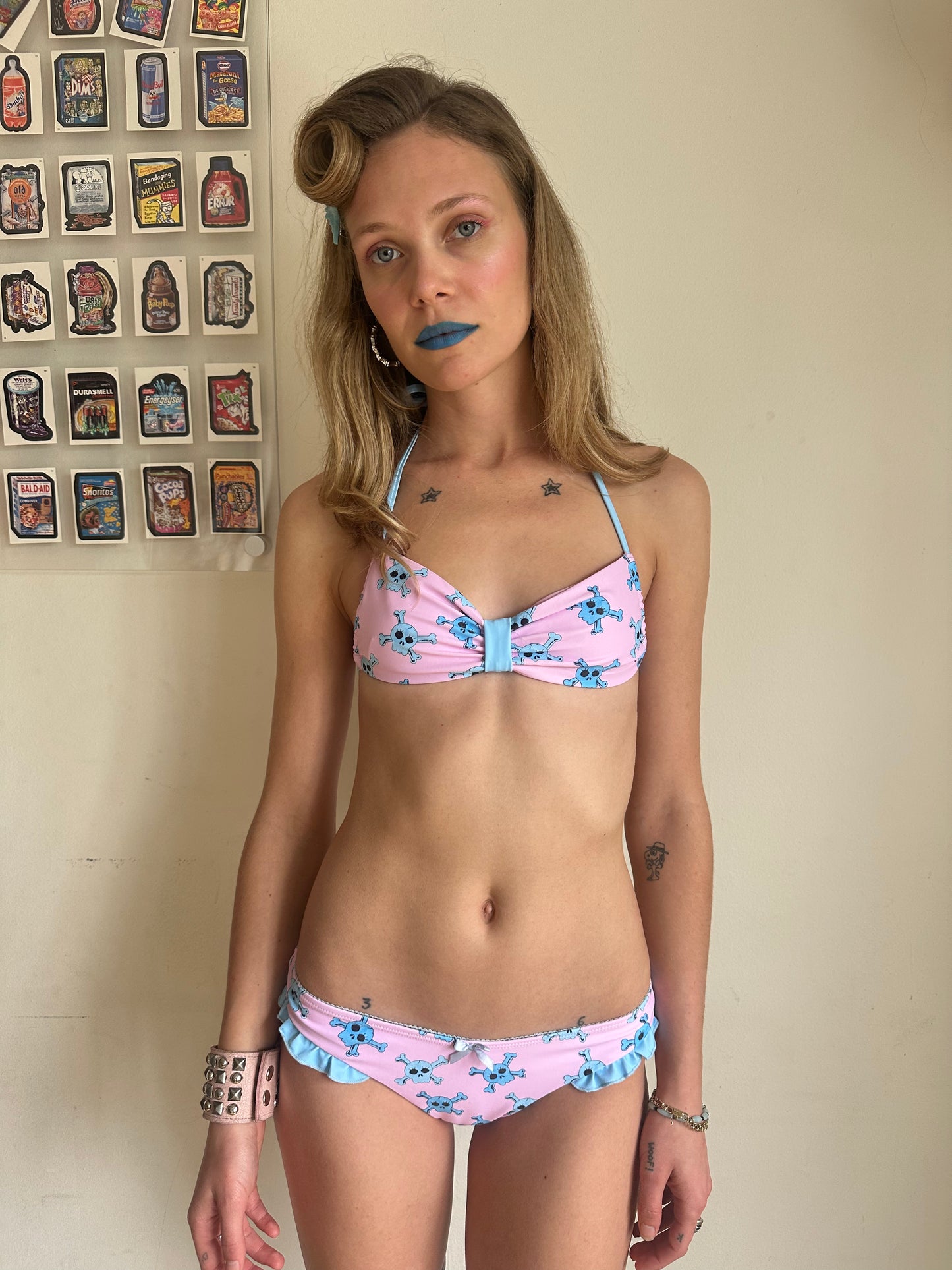 girl wearing pink bikini bottom with blue skull pattern with tall stripe socks