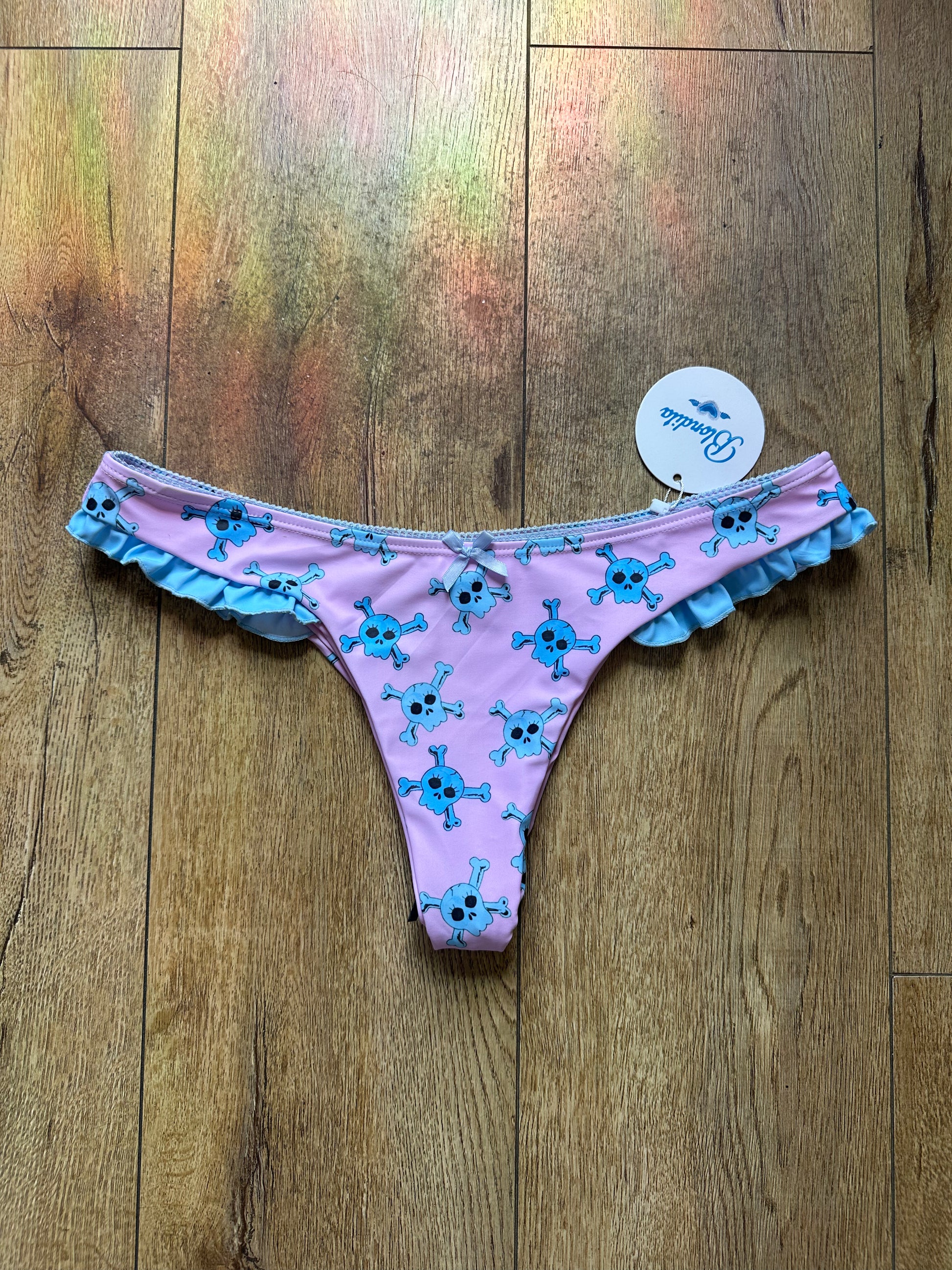 pink. bikini bottoms with blue skull pattern and blue trim