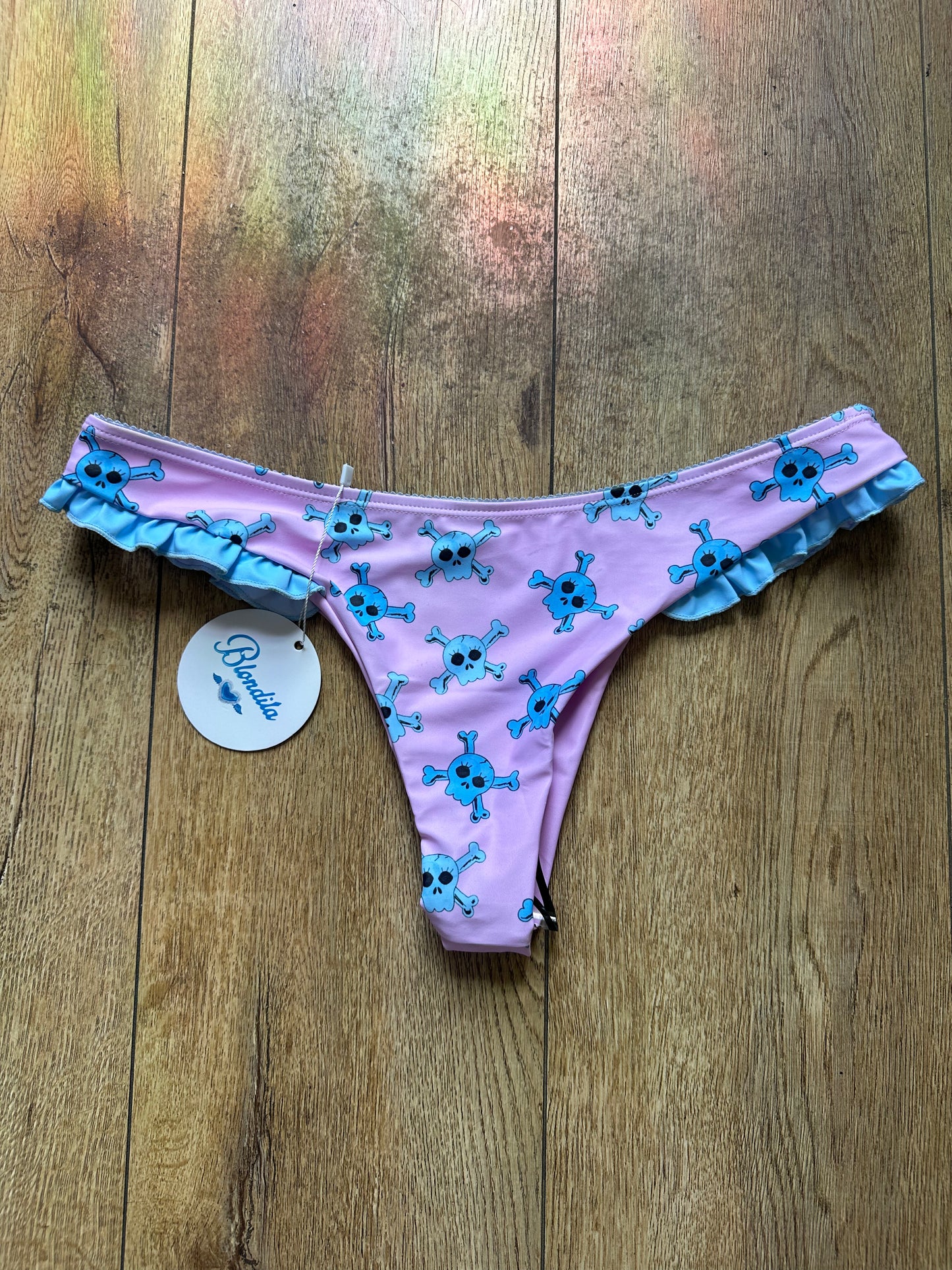 pink. bikini bottoms with blue skull pattern and blue trim