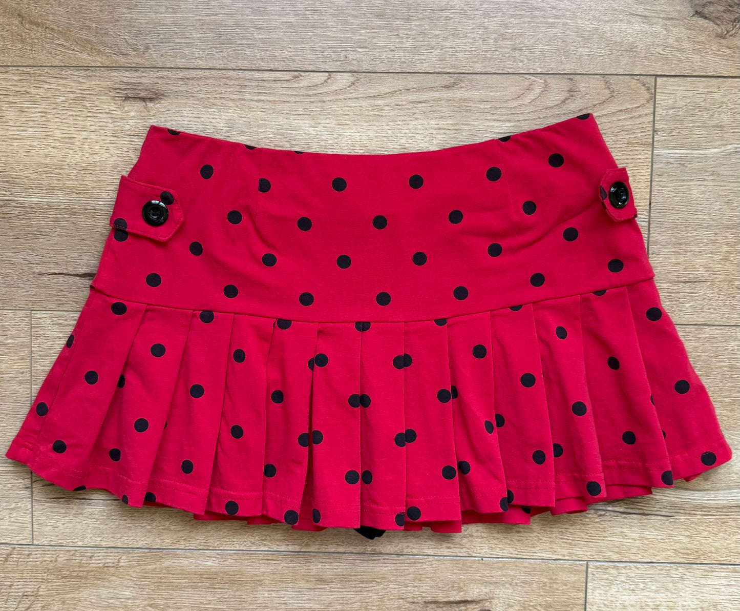 pleated red skirt with black polka dots and buttons on the side
