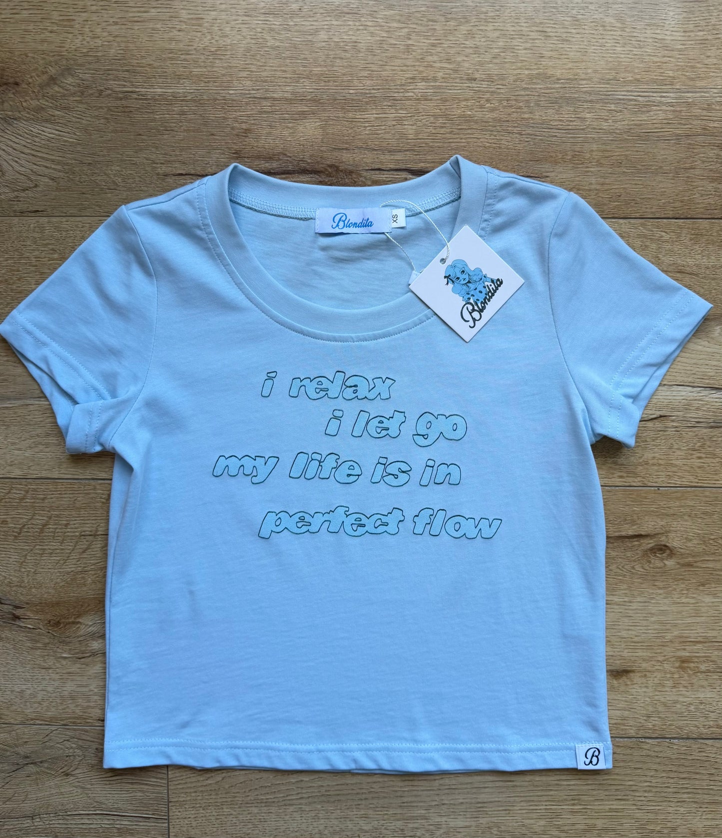 Light blue baby tee with a quote about relaxing 