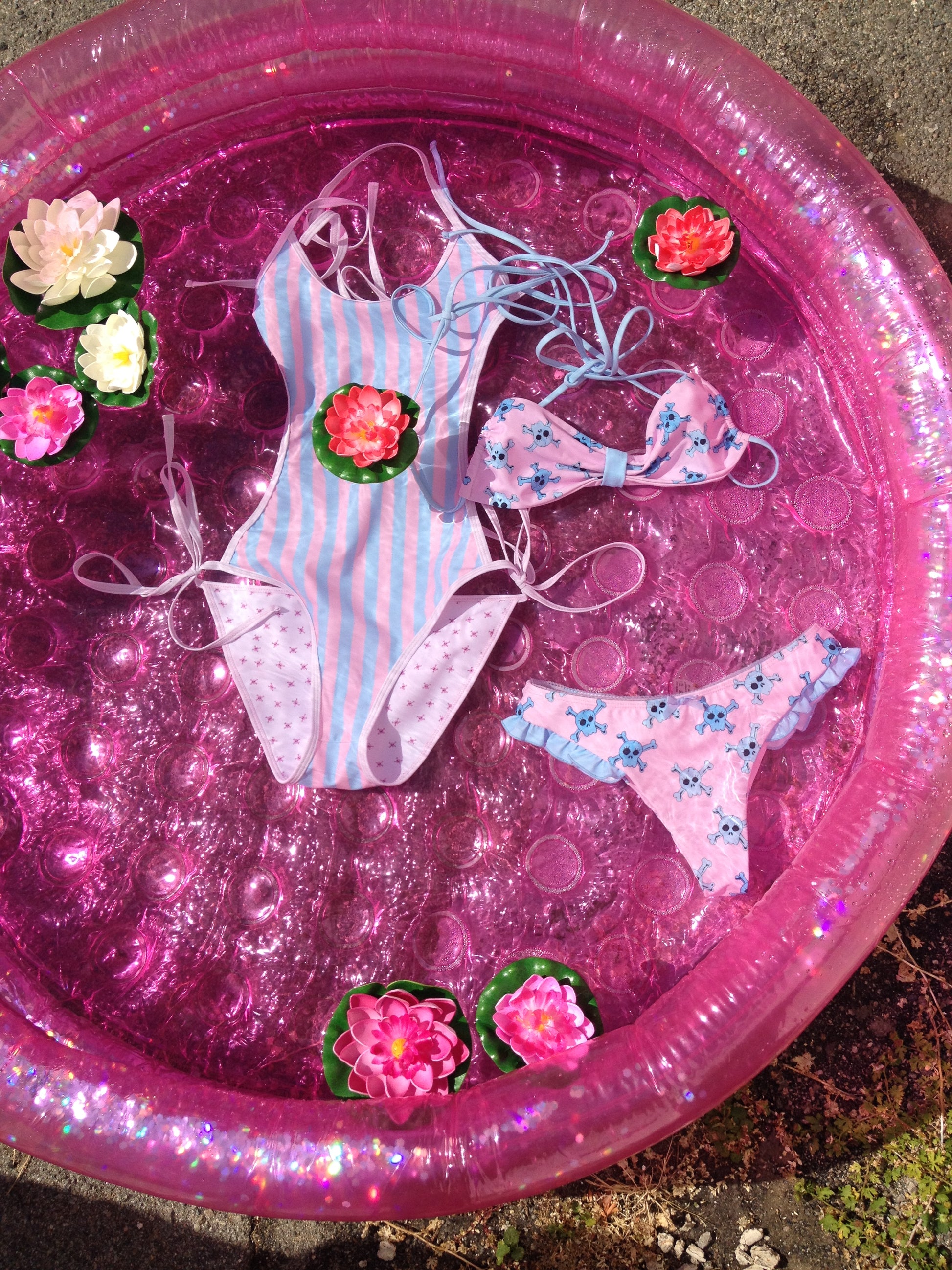 two bathing suits floating in a pool with lotus flowers 