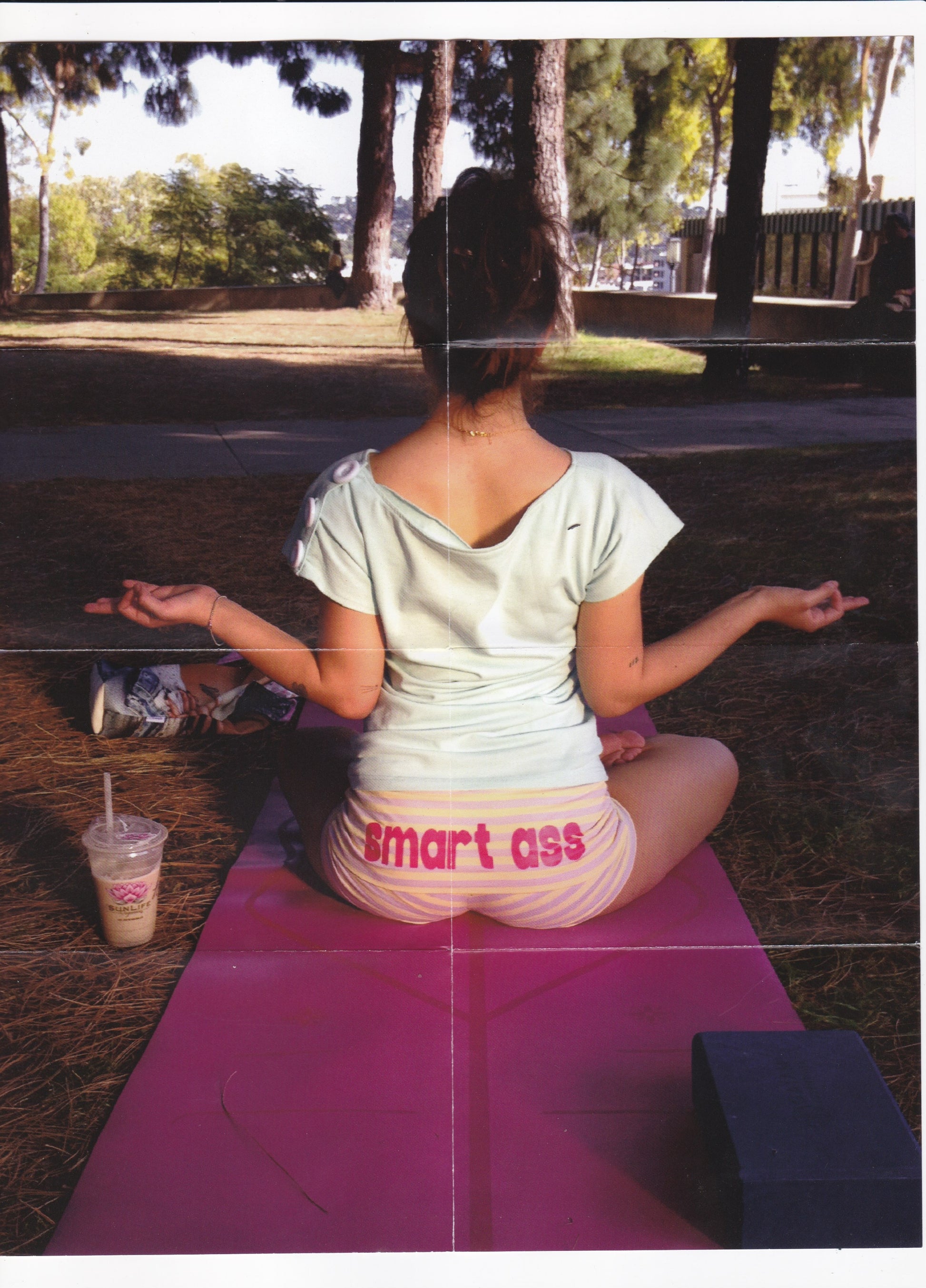 Girl meditating with a smoothie in the park