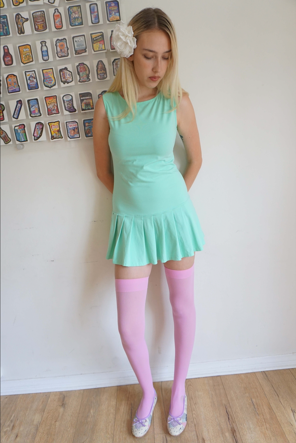 girl wearing a mint green drop waist pleated dress and tall socks