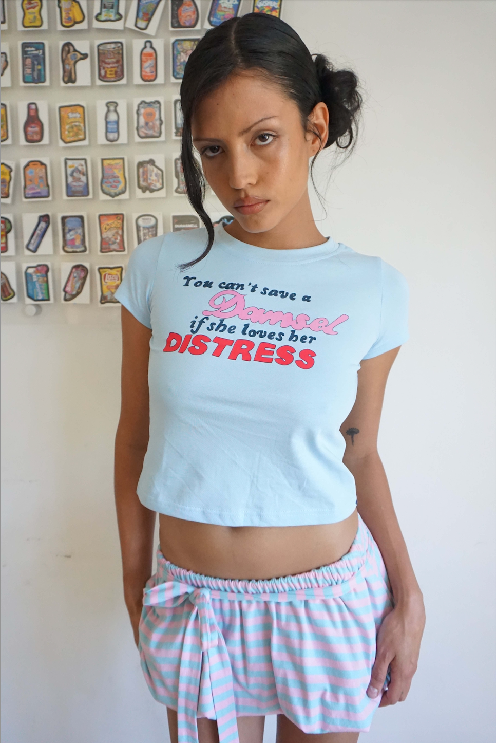woman wearing blue baby t shirt that says you can’t save a damsel if she loves her distress