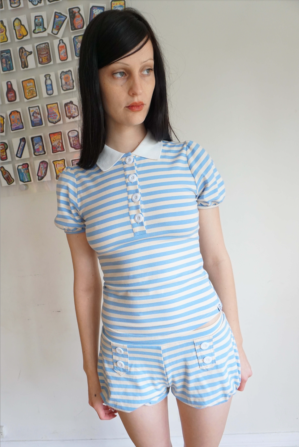 Girl with brown hair wearing a light blue and white stripe polo